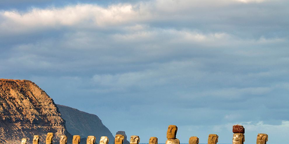 Met de rug naar de Stille Oceaan gekeerd staan vijftien gerestaureerde moais op wacht in Ahu Tongariki het grootste van de ceremonile stenen platforms op Paaseiland In 1960 werd deze moai door een tsunami landinwaarts gesleurd andere moais braken door het geweld van de tsunami in stukken