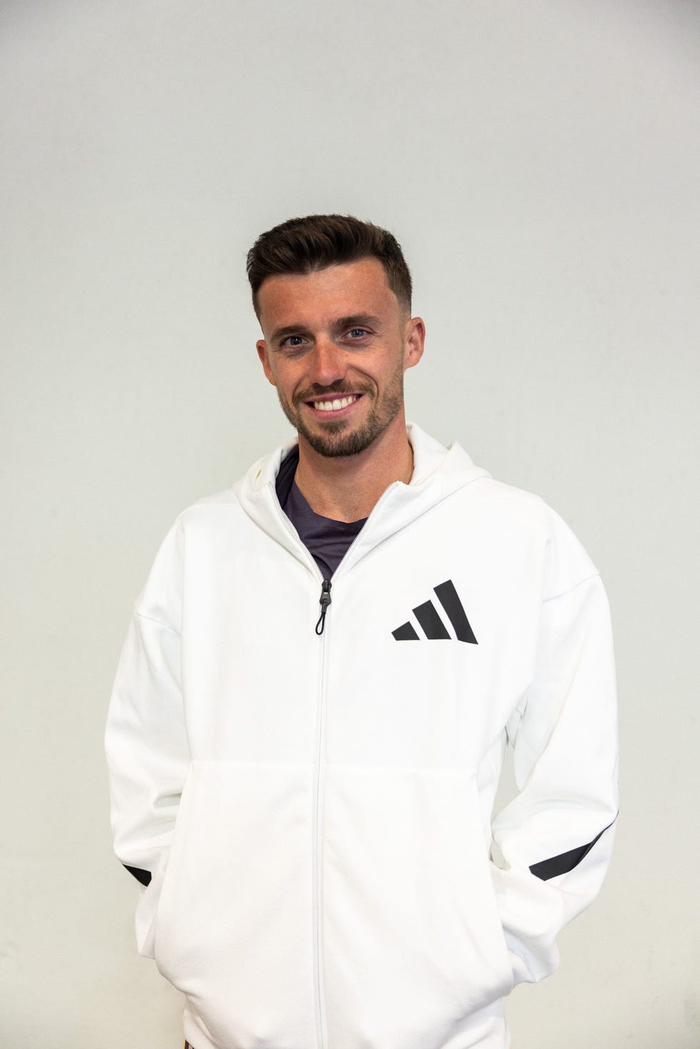 el atleta carlos mayo con la chaqueta adidas zne en color blanco y negro