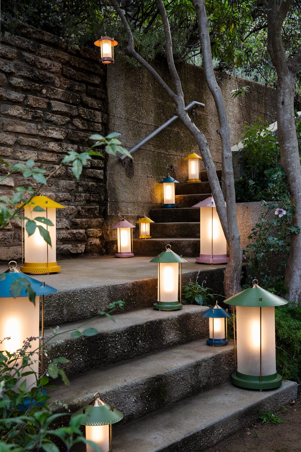 Colorful lanterns illuminating a stone staircase in a garden setting.