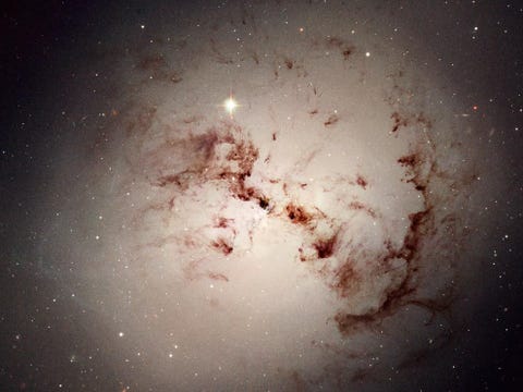 Te midden van NGC 1316 draaien kosmische stofnevels Dit is een gigantisch lensvormig sterrenstelsel dat miljarden jaren geleden is gevormd toen twee spiraalvormige sterrenstelsels samensmolten Astronomen hebben sterrenhopen van rode sterren in NGC 1316 onderzocht om vast te kunnen stellen dat dit enorme stelsel inderdaad door een grote botsing is ontstaan