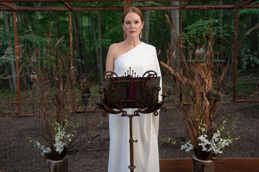 Ceremonial setting with a figure in white attire and decorative elements.