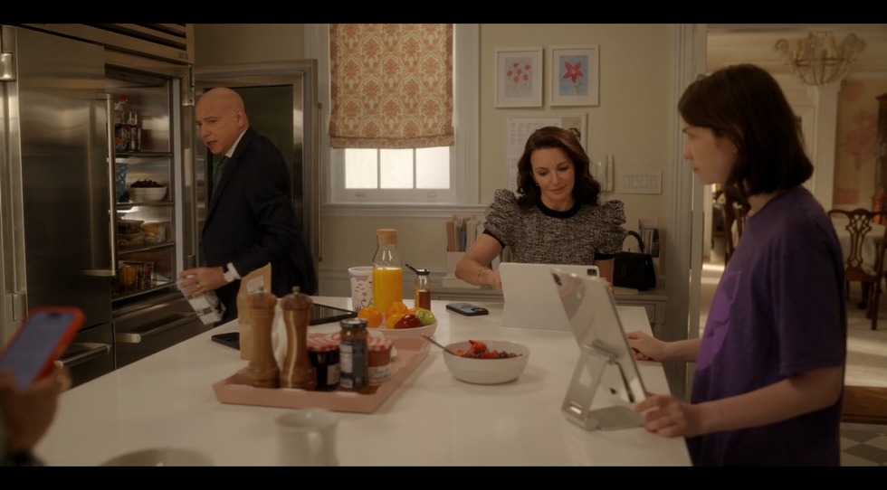 A kitchen scene with family members engaged in various activities.