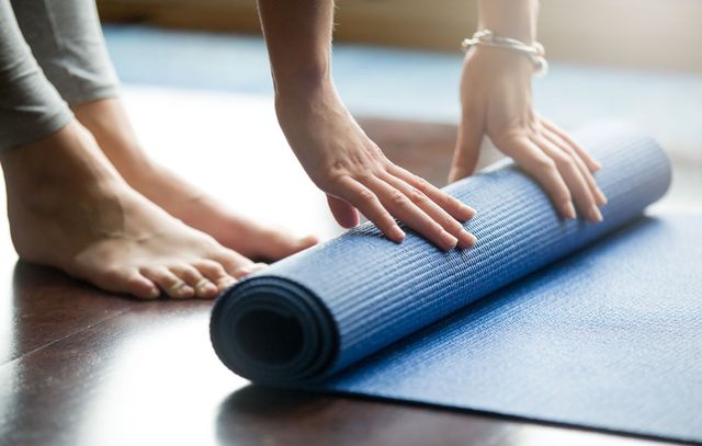 hands rolling up yoga mat