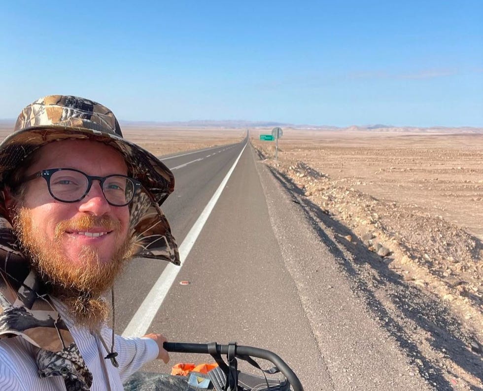 a cyclist on a road in a desert landscape