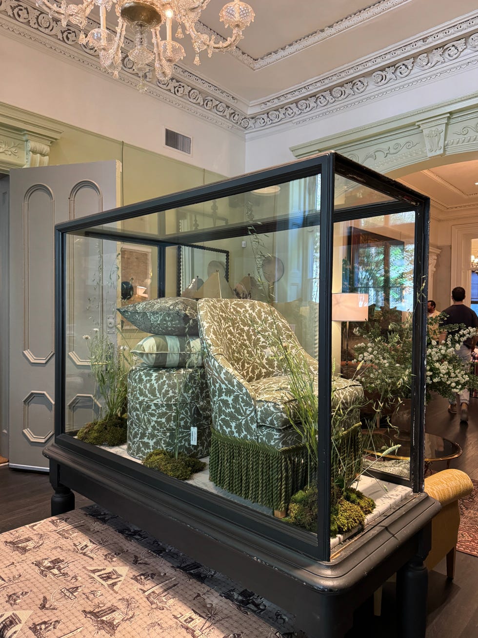 Display of upholstered furniture inside a glass case.