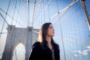 carlina poses on the brooklyn bridge