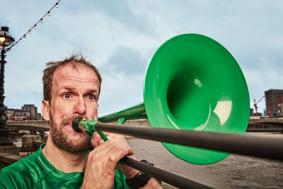 nat dye holding a green trombone