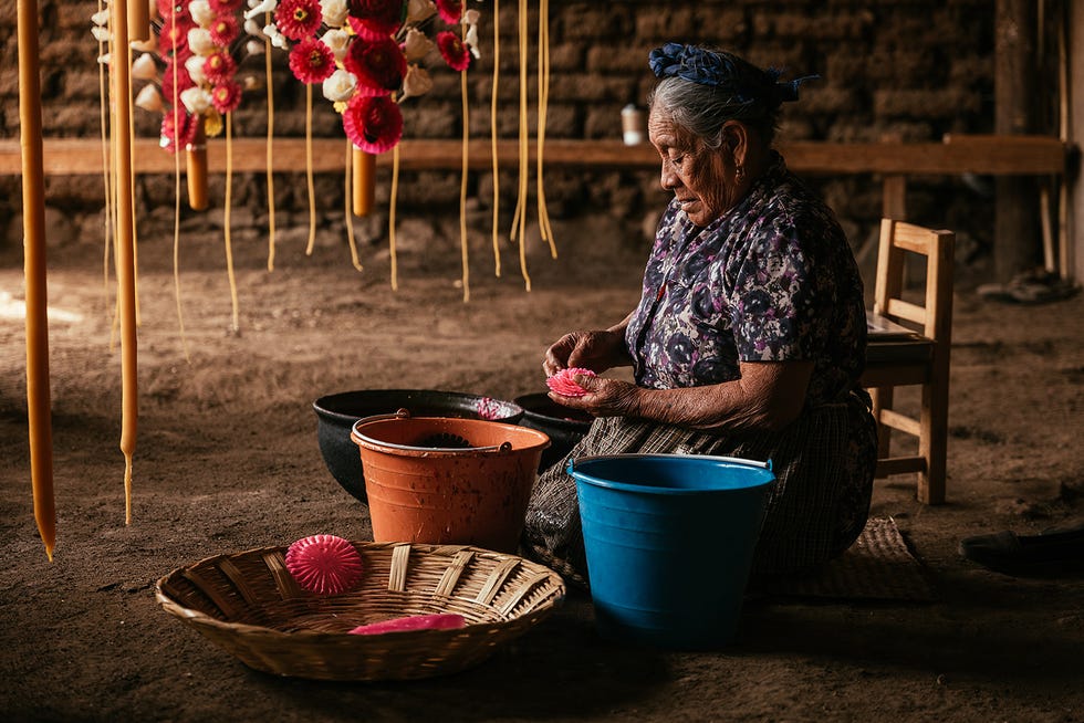 Woman crafting floral decorations in a workspace.