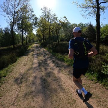 hardloper van team runner's world liep mas montagne trail amerongen over brede laan door het bos