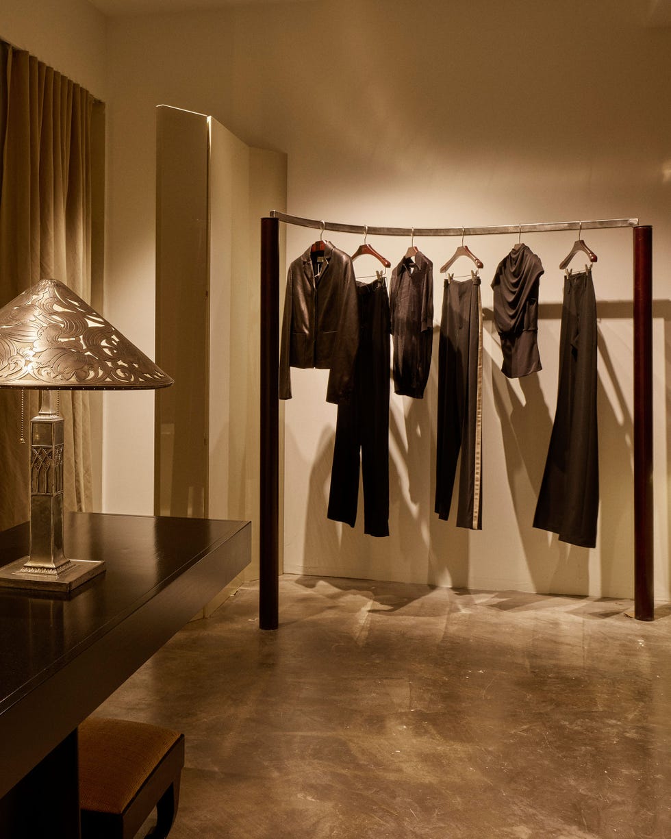 Clothing rack displaying fashion garments in a minimalist room.