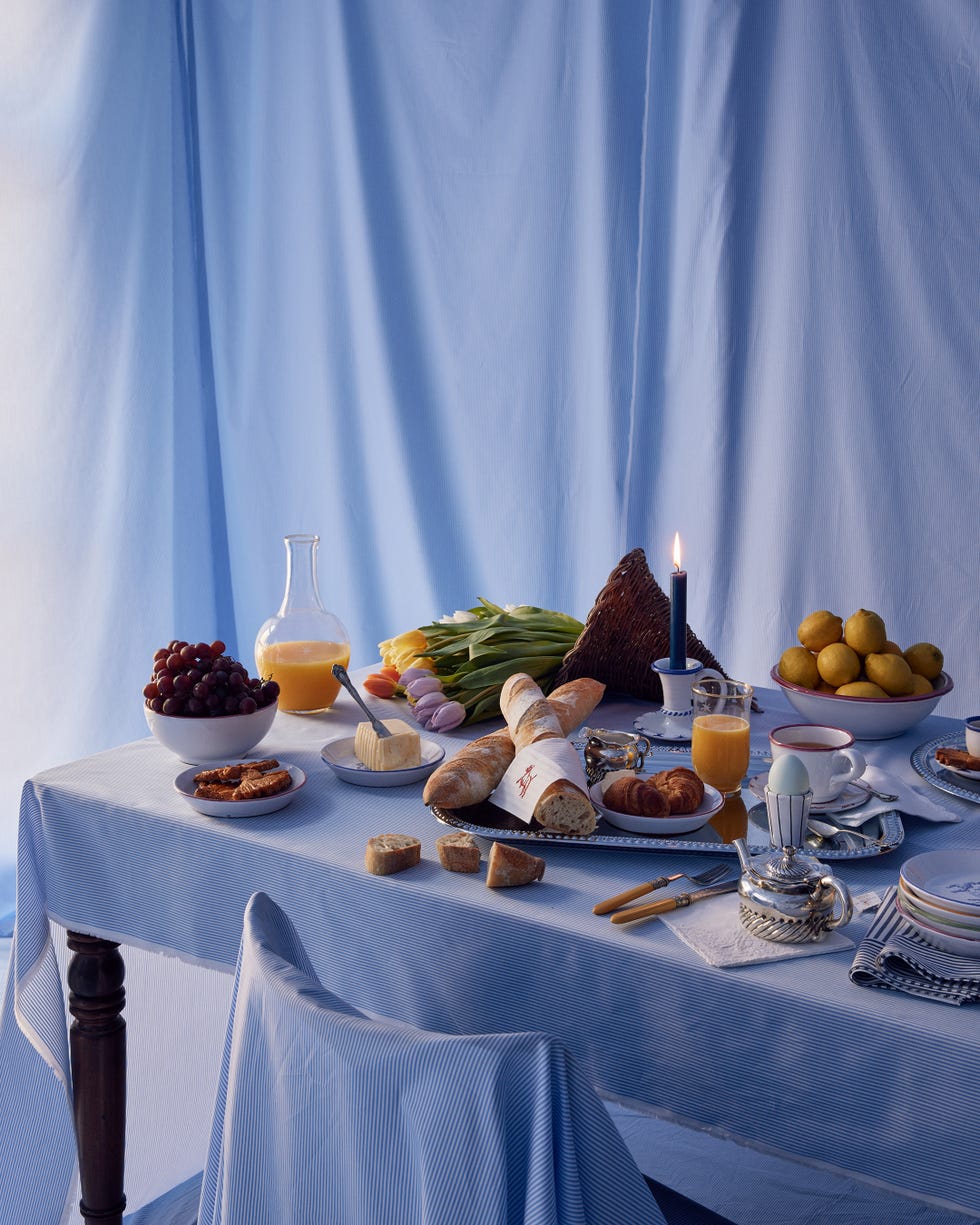 Breakfast table setting with a variety of food items and drinks.