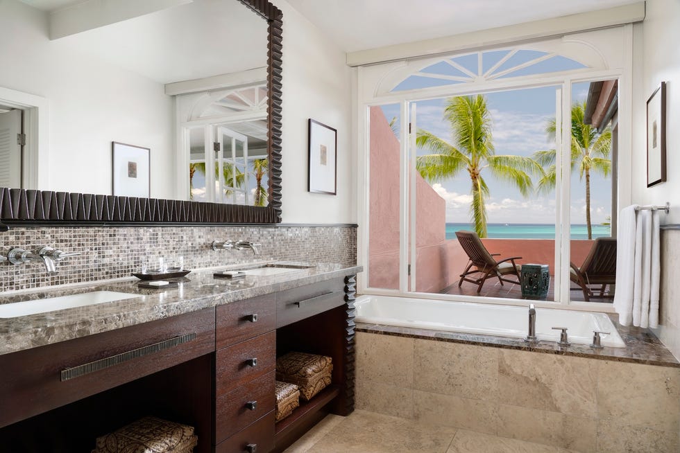 Luxury hotel bathroom with ocean view and modern fixtures.