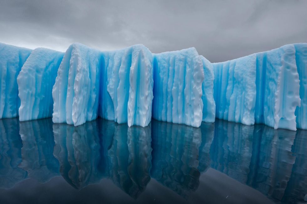 Deze ijsberg dankt zijn typische vorm aan erosie door warm water en warme lucht De diepe groeven ontstaan door het warme zeewater dat omhoog stroomt wanneer de onderkant onder water afsmelt Intussen smelt ook de bovenkant af waardoor de ijsberg lichter wordt en hoger in het water komt te liggen