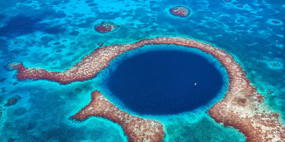 De Great Blue Hole een 130 meter diepe onderwatergrot is een van de vele highlights in het Barrirerif van Belize na dat van Australi het grootste koraalrif ter wereld De onderwatergrot die op Unescos werelderfgoedlijst voorkomt is een populaire attractie onder duikers sinds filmmaker JacquesYves Cousteau begin jaren 70 met zijn schip Calypso er de diepte kwam opmeten
