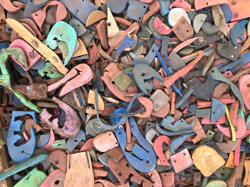 Recycling van teenslippers op de bodem van een rotsklimgebied bij Nairobi