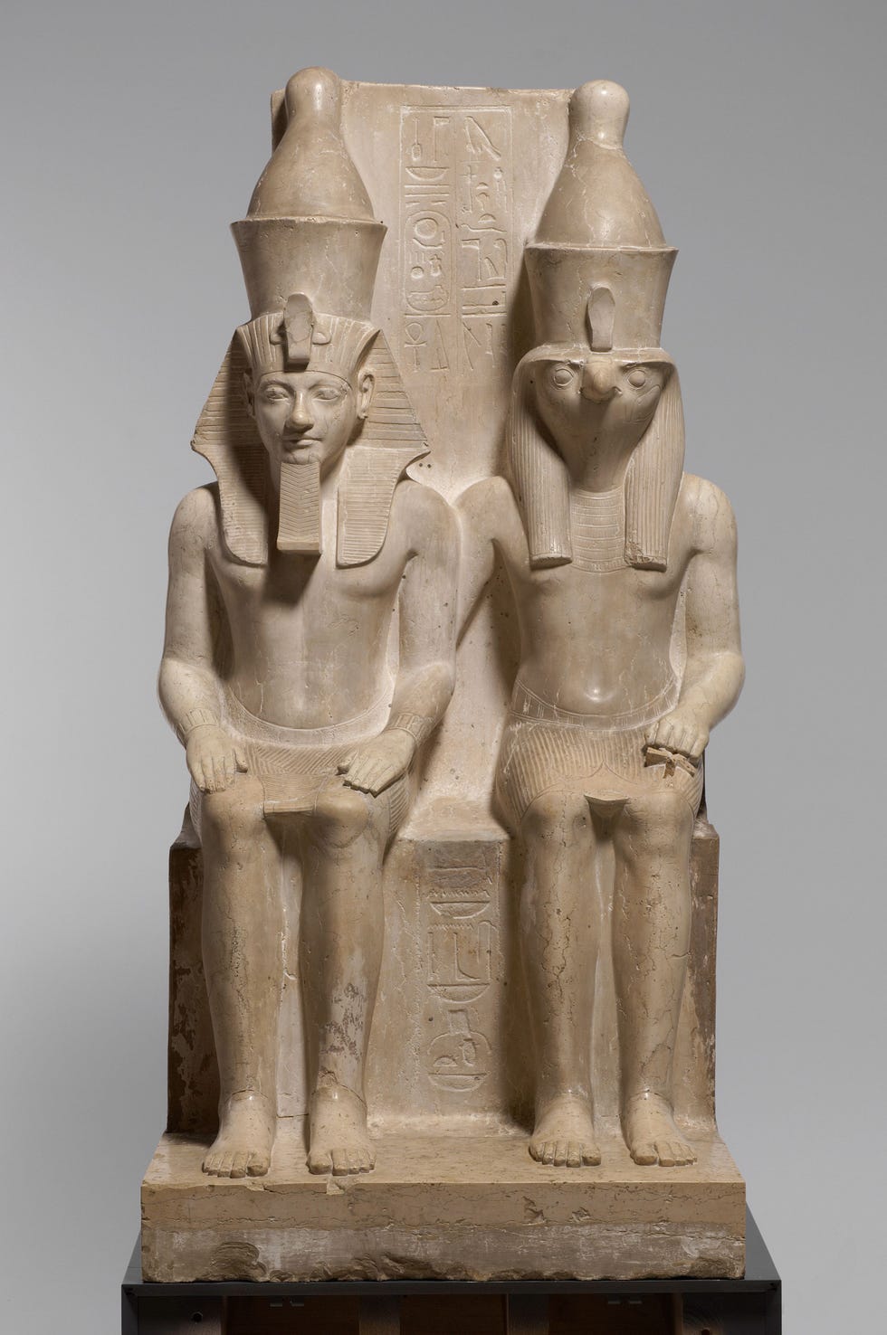 Farao Horemheb links is even groot afgebeeld als de god Horus hun status was gelijkwaardig Kalksteen 152 cm 18de dynastie 13191305 vC