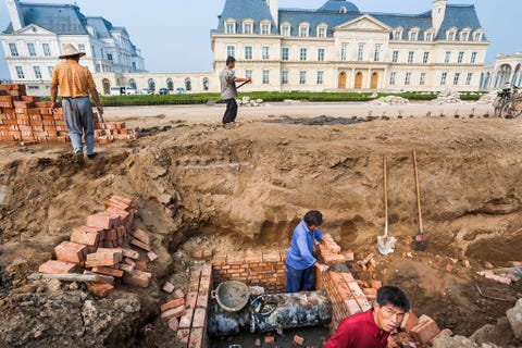 Arbeiders leggen de laatste hand aan het hotel Chteau Zhang Laffitte een replica van het Franse landgoed Chteau de MaisonsLaffitte uit de zeventiende eeuw Honderden boeren moesten worden onteigend en plaatsmaken voor een bouwwerk dat het middelpunt zal vormen van een groot onroerendgoedproject De boeren kunnen solliciteren op het slecht betaalde werk dat nodig is voor het onderhoud van het complex Beijing China 2005