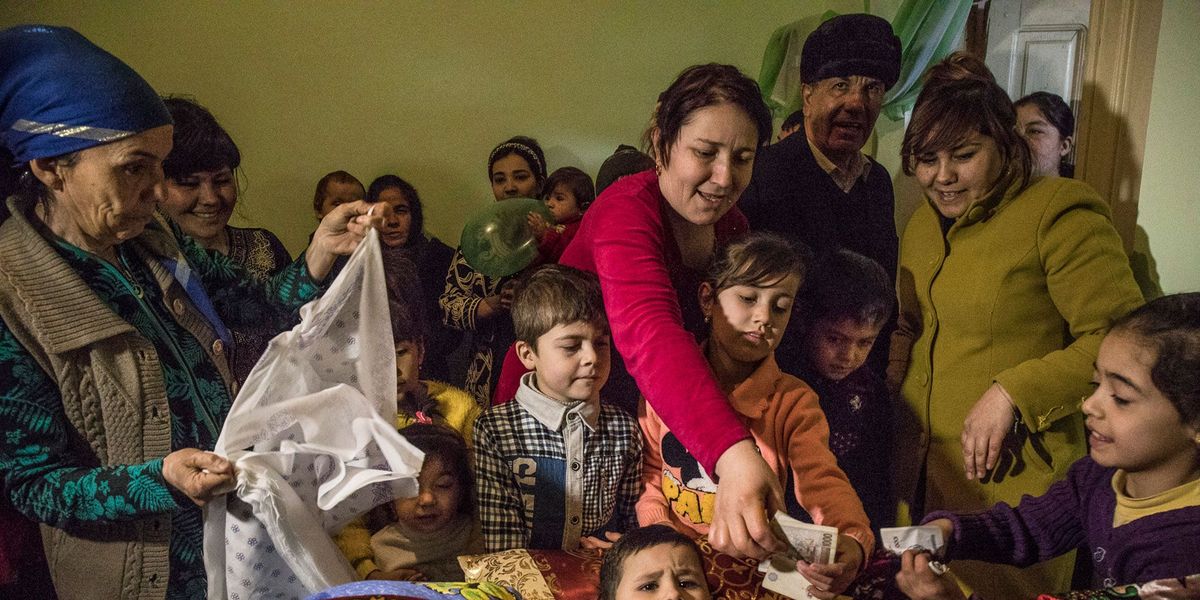De 5jarige Beknur Bakhtiarov krijgt geld cadeau na zijn besnijdenis in zijn ouderlijk huis in Xiva in Oezbekistan