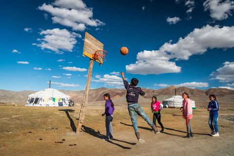 Kinderen spelen een potje basketball achter de gers van hun familie Niet alleen westerse invloeden zoals sport en kleding maar ook de aanleg van een nieuwe snelweg door de Chinese overheid heeft invloed op het traditionele bestaan in WestMongoli