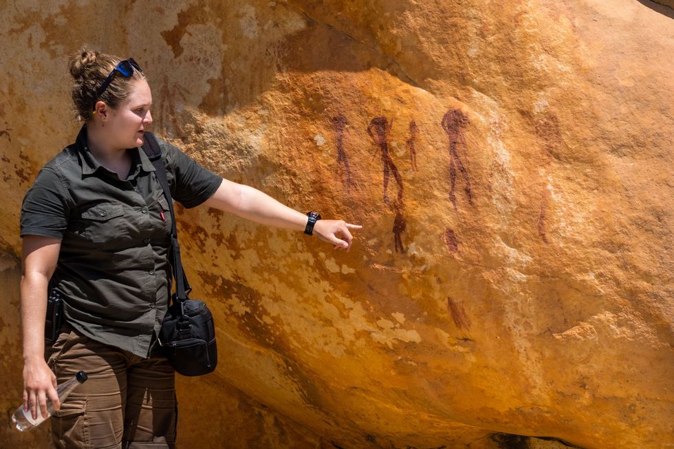 Parkwachter Samantha toont een van de duizenden jaren oude rotstekeningen van de San