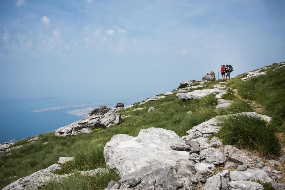 Twee hikers pauseren naast het pad bij de Velebitbergen