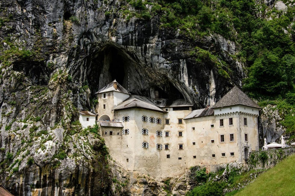Het kasteel Predjamski Grad ligt aan de voet van een grot aan het begin van de Via Dinarica in Postonja Sloveni