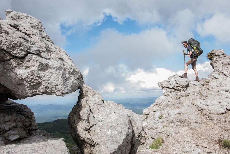 Een hiker kijkt uit over de Adriatische Zee vanaf de top van de berg Snenik in Sloveni