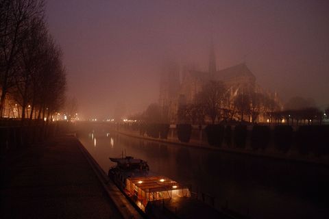 Een nachtelijke foto uit de jaren 80 toont de schimmige kathedraal aan de overkant van de Seine