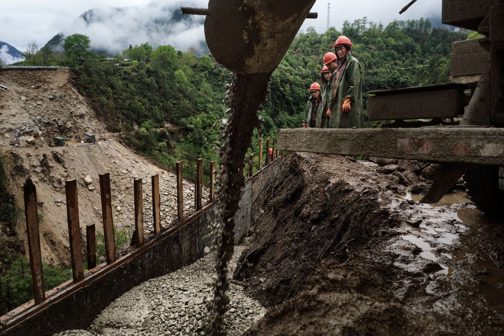 Werkmannen uit Yunnan bouwen een brug in het dorp van Zhong Ding bij de Nu rivier De overheid heeft plannen de weg om te bouwen tot een snelweg die naar Tibet en diens hoofdstad Lhasa moet leiden