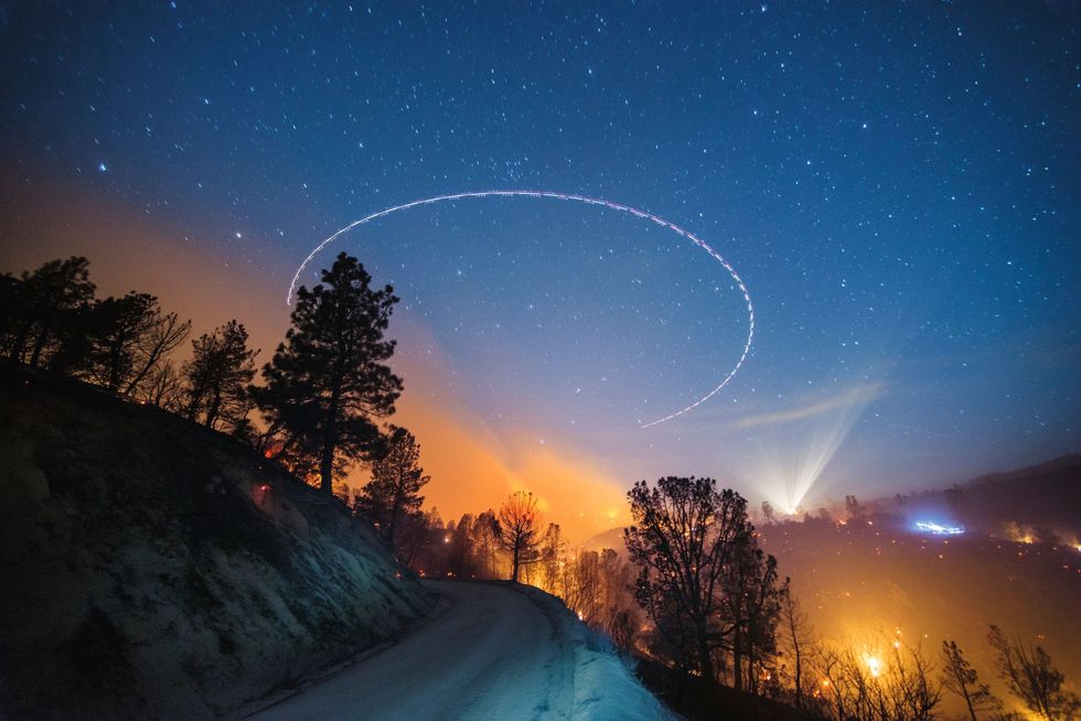 Op een foto met een lange sluitertijd is te zien hoe de Amerikaanse Forest Service bij Lake Isabella Californie over een bosbrand in Sequoia National Forest vliegt om infraroodfotos te maken De brandweer projecteert deze data op kaarten en ziet zo precies waar er geblust moet worden en wat de mogelijke risicos zijn