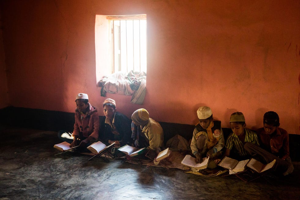 In een madrassa in een van de oudere gedeelten van het kamp van Kutupalong bestuderen jongens de koran De meeste Rohingyakinderen in Bangladesh hebben geen toegang tot formele scholing omdat ze als illegale vluchtelingen worden gezien De meeste gaan naar een van de vele madrassas die in de kampen zijn opgericht