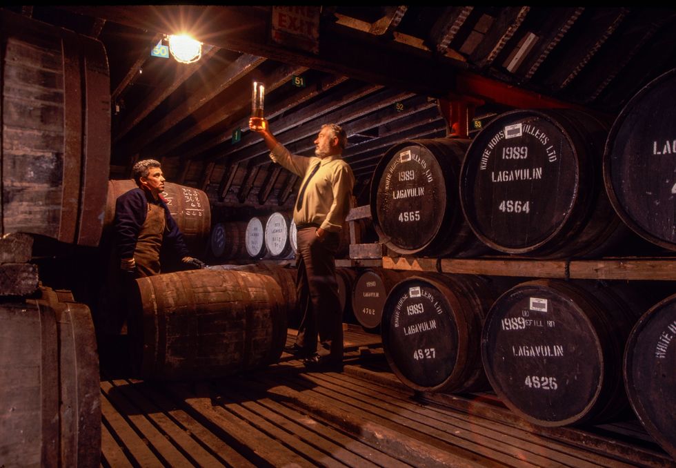 Alex Gunn en William Campbell van distilleerderij Lagavulin op het eiland Islay controleren een vat om te zien hoe de whisky rijpt