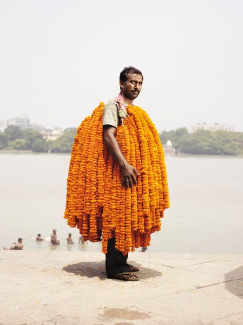 Verkoper Kulwinder draagt wat oogt als een jurk van afrikaantjes Om deze mannen ertoe te verleiden in de hitte te poseren kocht ik meestal alle bloemen die ze bij zich hadden