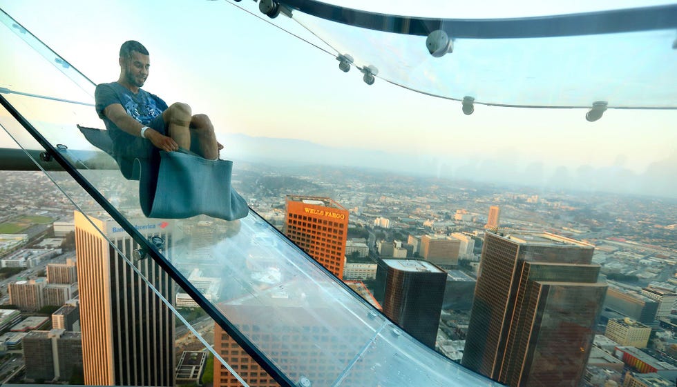 Tijdens de grootse opening in 2016 van de OUE Skyspace in Los Angeles in Californi zoeft een bezoeker over de Skyslide