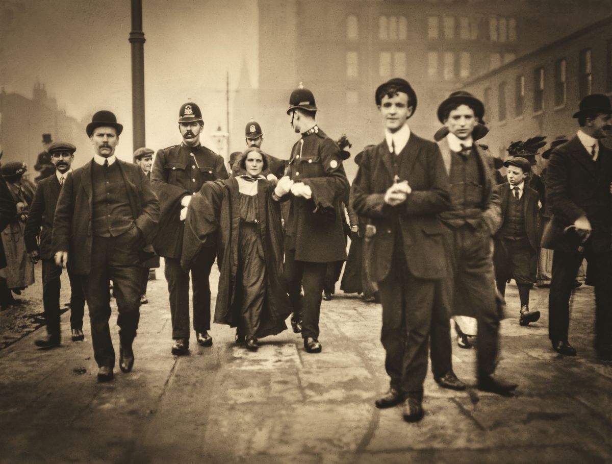 De politie van Manchester arresteert een suffragette tijdens een straatprotest rond 1905 toen de strijd voor het vrouwenkiesrecht in volle gang was De aangehouden jonge vrouw draagt een toga omdat zij verbonden is aan de universiteit