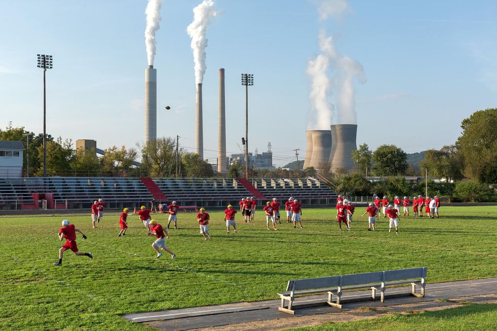 Een voetbalteam van een school in Poca West Virginia traint voor een steenkoolcentrale die zon twee miljoen huizen van energie voorziet