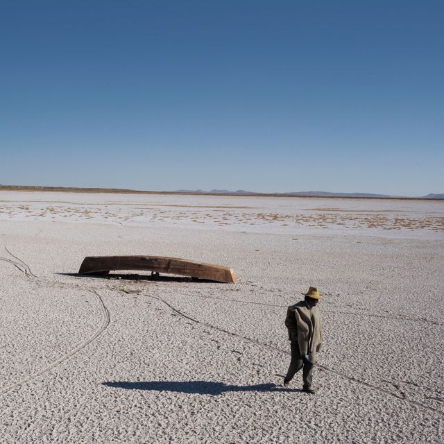 Als een eindeloze zoutvlakte strekt het opgedroogde meer zich uit naar de Boliviaanse horizon Hier en daar ligt nog een bootje de vissen en watervogels zijn verdwenen De vissers die van het meer leefden zijn uitgezwermd in een door droogte veroorzaakte diaspora