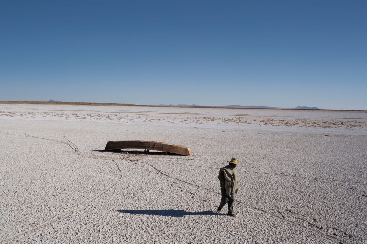 Als een eindeloze zoutvlakte strekt het opgedroogde meer zich uit naar de Boliviaanse horizon Hier en daar ligt nog een bootje de vissen en watervogels zijn verdwenen De vissers die van het meer leefden zijn uitgezwermd in een door droogte veroorzaakte diaspora