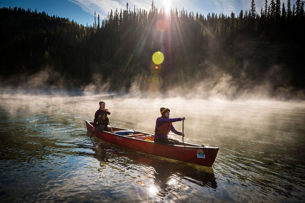 In de vroege ochtend vaart een kano op de stroming van de Yukon River naar het noorden Yukon is een eldorado voor kajakkers de hele route die een afstand van zon 3000 kilometer beslaat is met een kano te bevaren