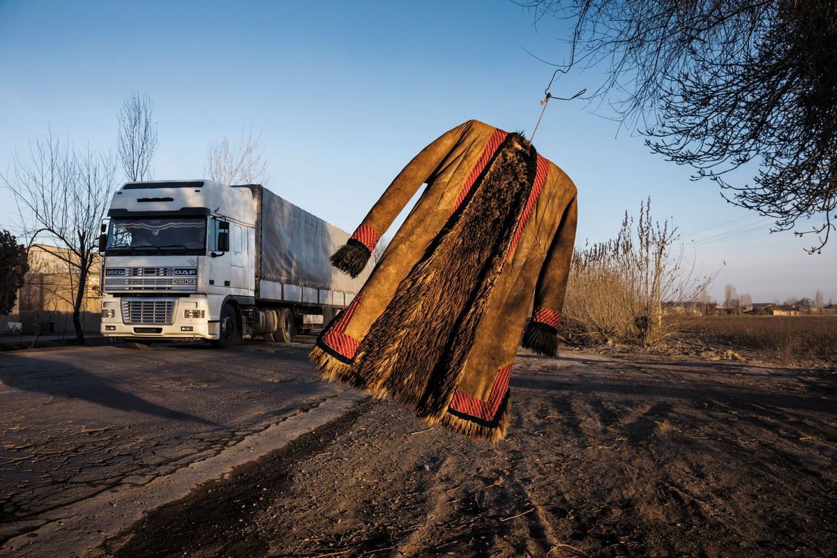 Een traditionele jas van schapenvacht wappert in de wind in Tortkol Oezbekistan op een hoofdweg die de oude zijderoute volgt Dat was niet een weg maar een netwerk van handelsroutes dat zich uitstrekte van Europa naar China