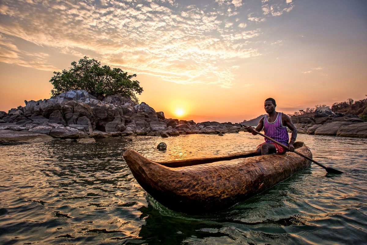 Bij zonsopgang begint een visser zijn dag in een zelfgemaakte kano in het zuidelijke deel van het Malawimeer