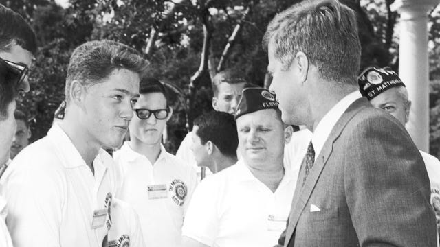 Bill Clinton, a teenage boy, shakes the hand of President John F. Kennedy