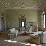 an old renaissance style building in italy with a white sofa and chair around a white oak coffee table