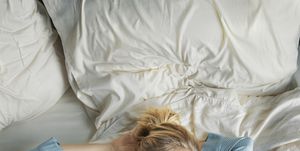 weekend mornings a beautiful blonde woman in blue pajamas lying in bed in the morning
