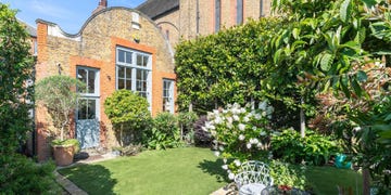 converted schoolhouse and garden next to a church