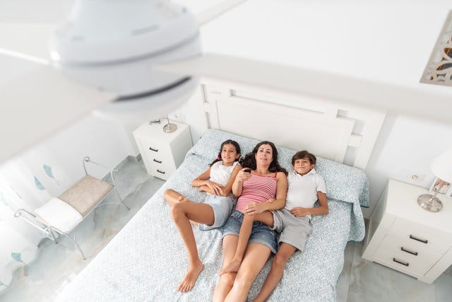 a family uses the remote to activate the electric ceiling fan, view from above