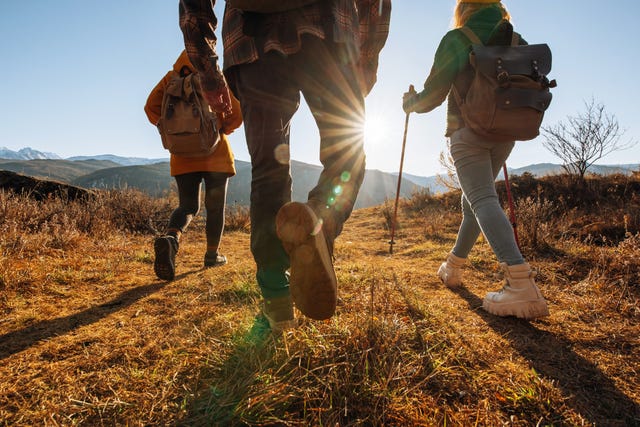 a group of people walking with backpacks in the mountains on a hike