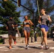 three runners jogging across a crosswalk
