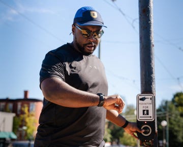 a person pressing a pedestrian crosswalk button