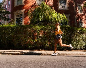 a runner passing a wall covered in ivy